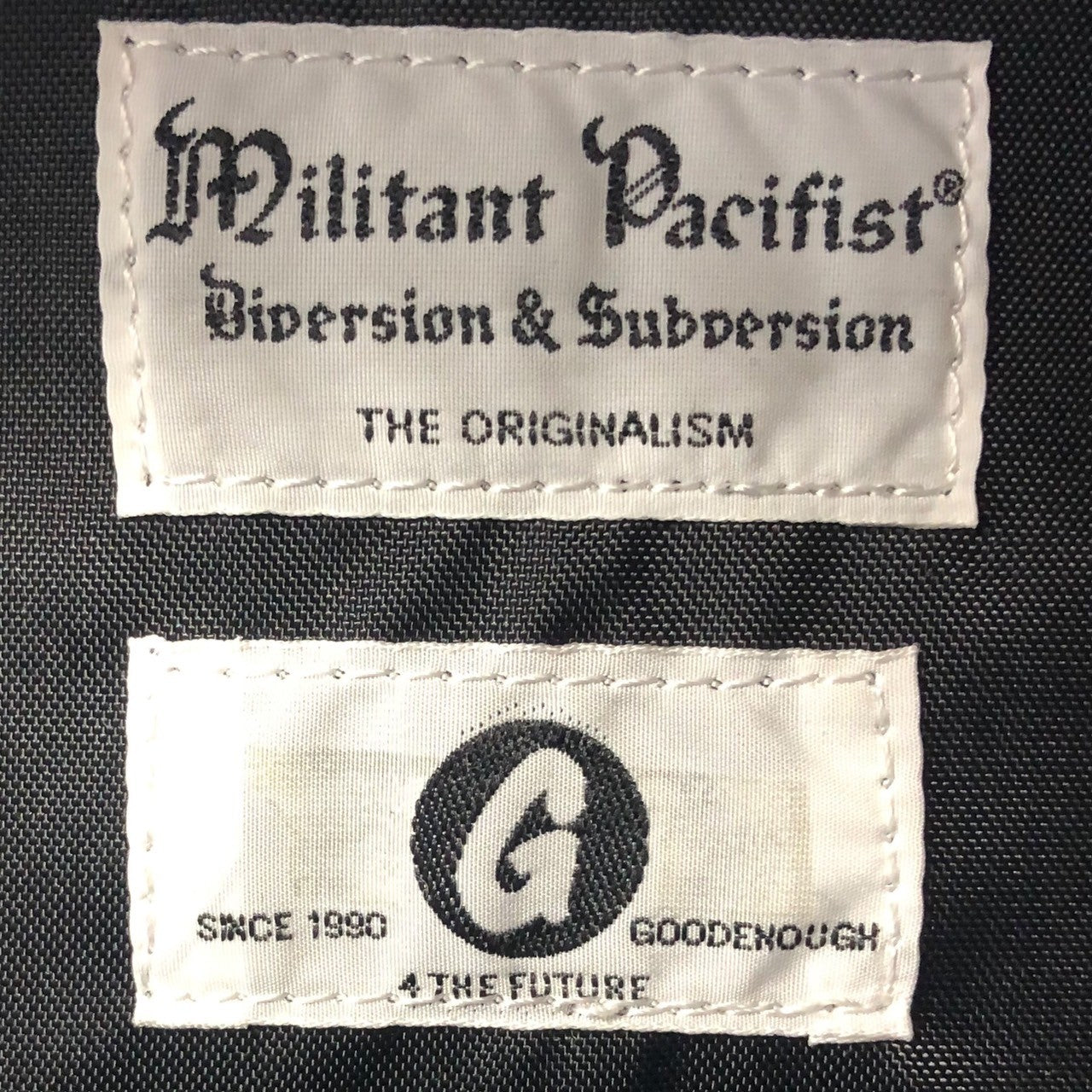 GOODENOUGH × militant pacifist × FABRICK(グッドイナフ×ミリタントパシフィスト×ファブリック) all over logo backpack ロゴ リュック バックパック ブラック×ホワイト